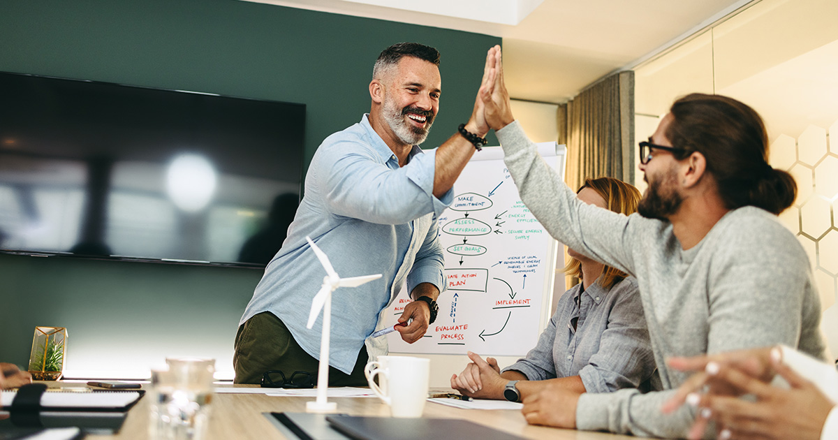 Successful business people giving each other high-fives during a meeting
